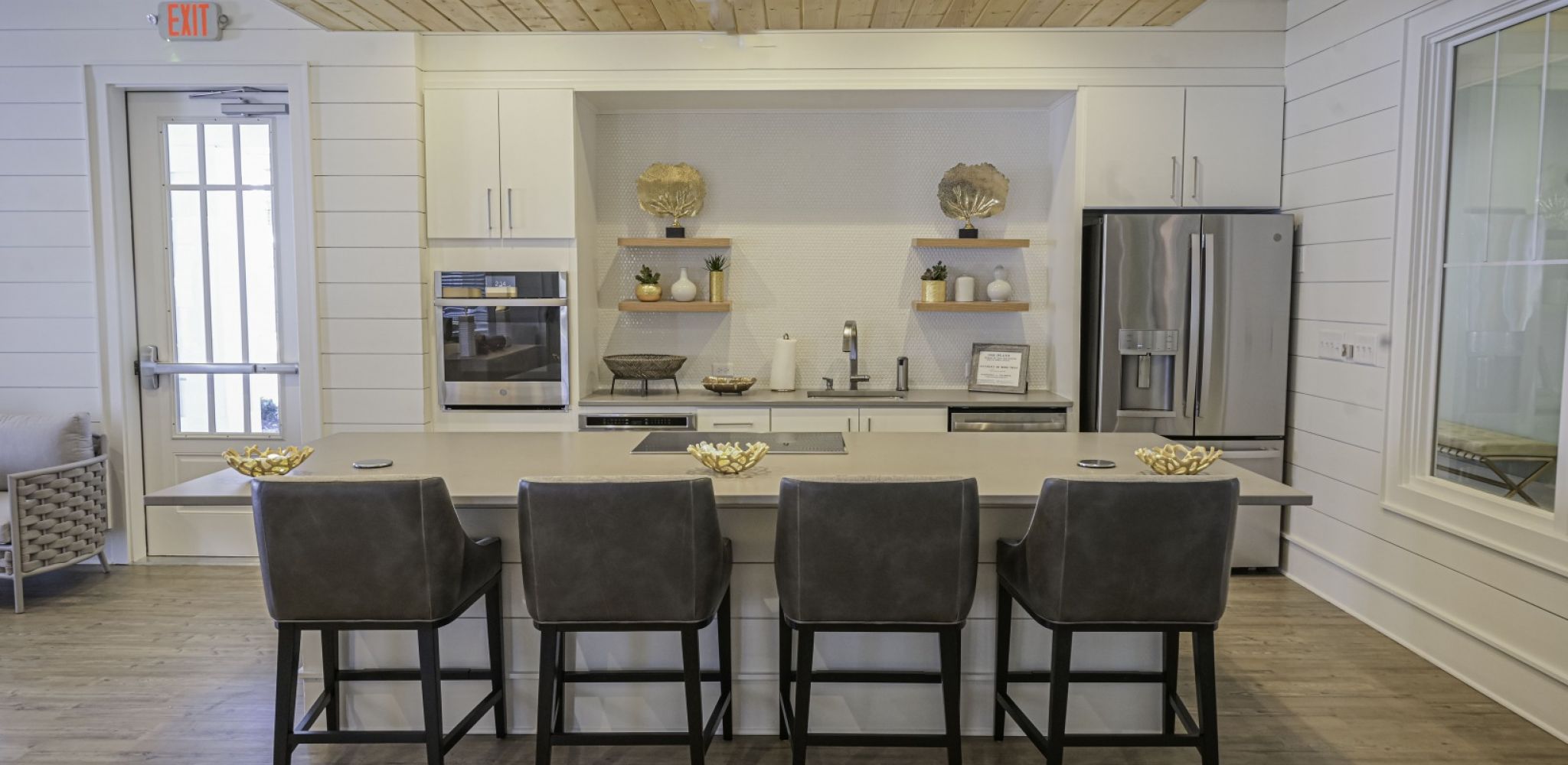 Hawthorne at Pine Forest resident amenity area with large island with chairs, stainless steel appliances, and a large sink